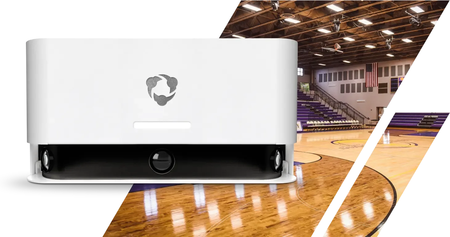 A white Hudl Focus camera system is positioned in a gym setting, ready to capture basketball games automatically.