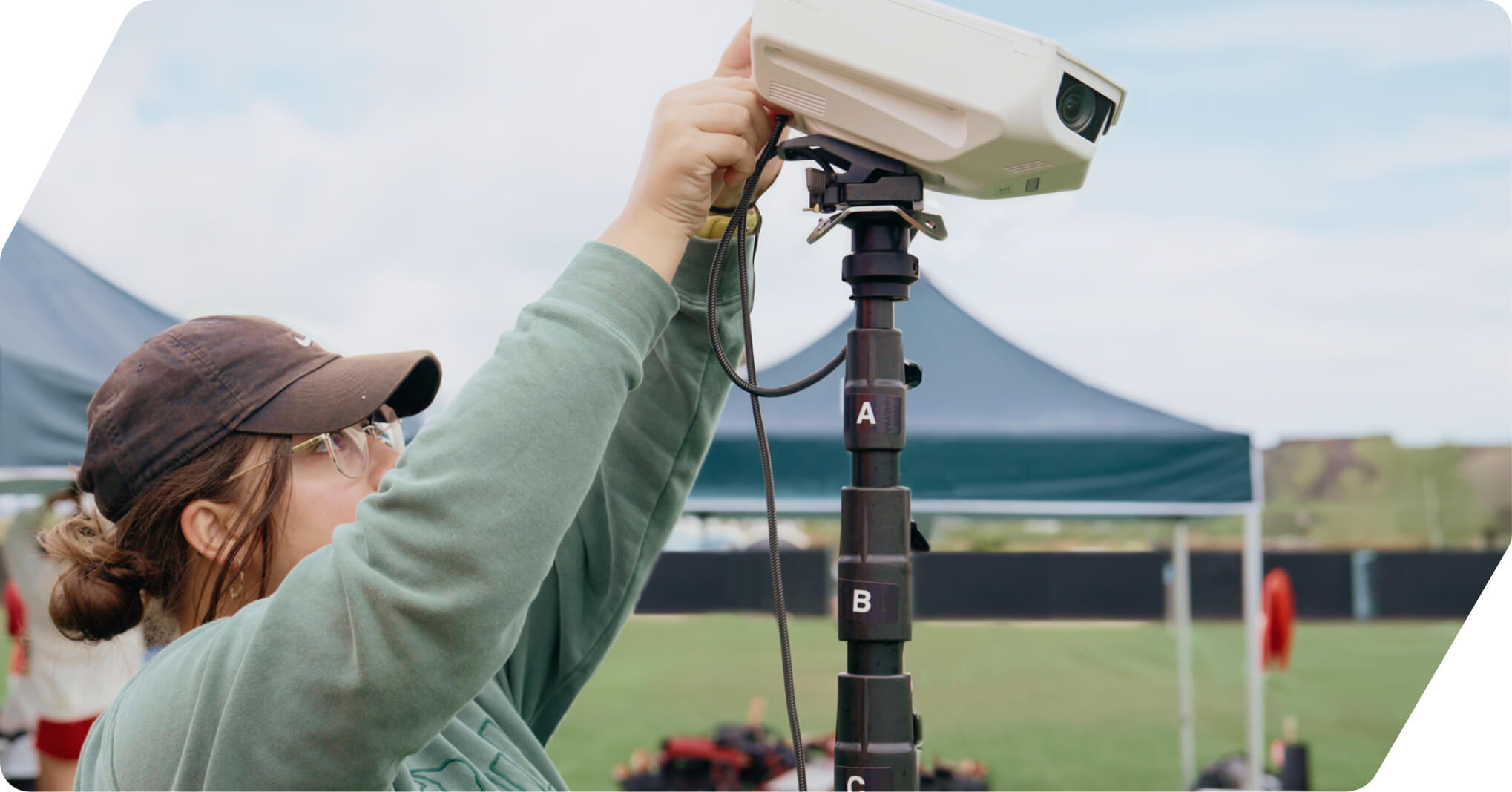 Photo of a woman setting up a focus flex camera on a soccer pitch