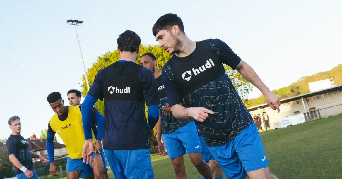 a group of football athletes wearing Hudl GPS tracker vests doing drills