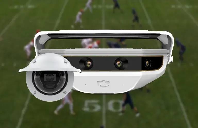 A Focus Point dome camera and a Hudl Focus smart camera are shown in the foreground, set against a blurred background of an American football game in progress on a grass field.
