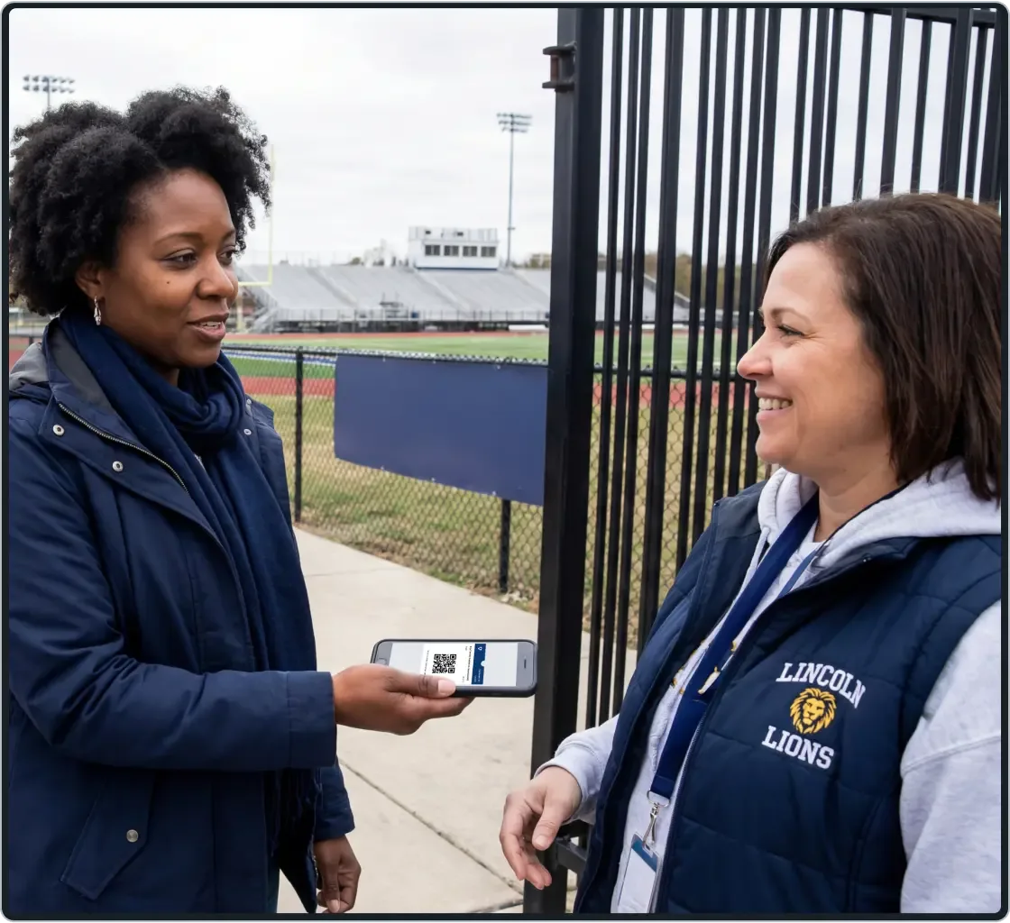 A fan using their phone to show a Hudl Ticket to a ticket taker at a sporting event.